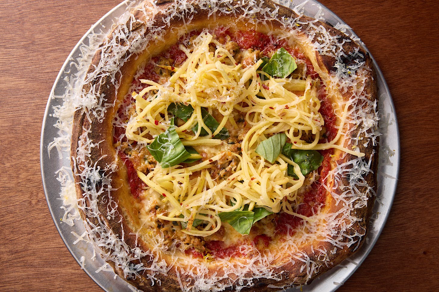 A red sauce-based pizza topped with shredded potato at Norma Taps.